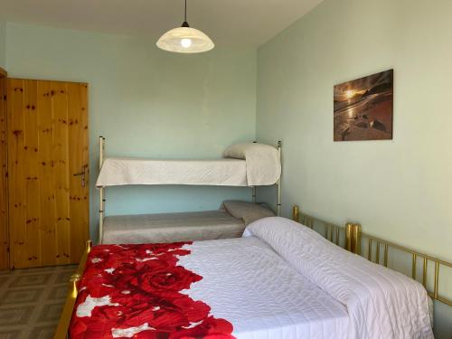 ポルト・チェザーレオにあるAppartamento Solariaのベッドルーム1室(二段ベッド2組、赤いバラのカーペット付)