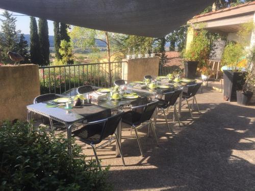 a group of tables and chairs under an umbrella at Mas Du Cadranier in Villeneuve