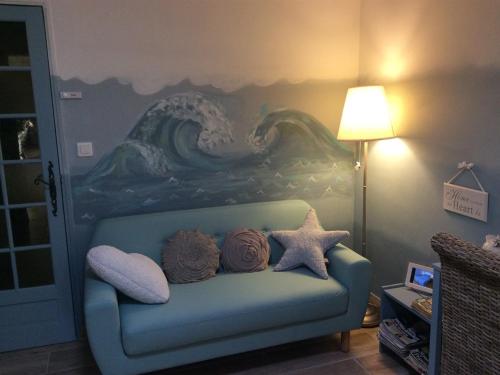 VilleneuveにあるMas Du Cadranierの青いソファが備わる壁画のある部屋