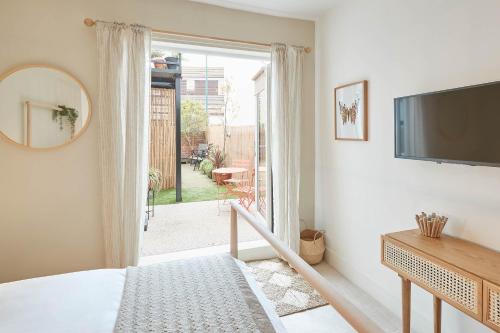 a bedroom with a large window and a television at Host & Stay - Retreat By The Sea in Marske-by-the-Sea