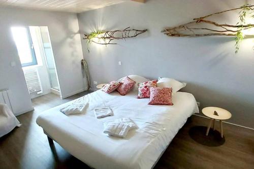 a bedroom with a bed with white sheets and red pillows at Domaine de Solémy in Bully