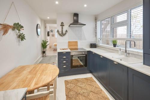 a kitchen with blue cabinets and a wooden table at Host & Stay - Retreat By The Sea in Marske-by-the-Sea