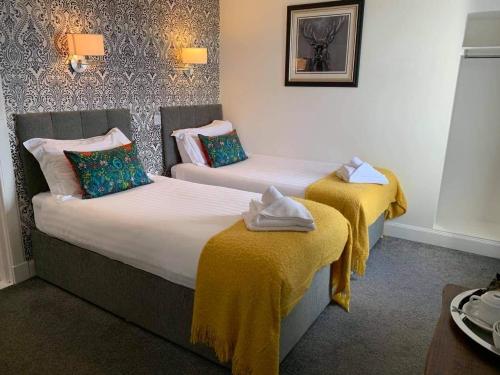 a hotel room with two beds with yellow blankets at No. 1 Charlotte Street in Port Ellen