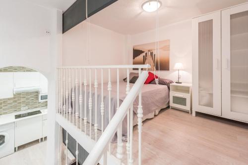 um quarto branco com uma cama e uma escada em La Estancia de Montserrat em Madri
