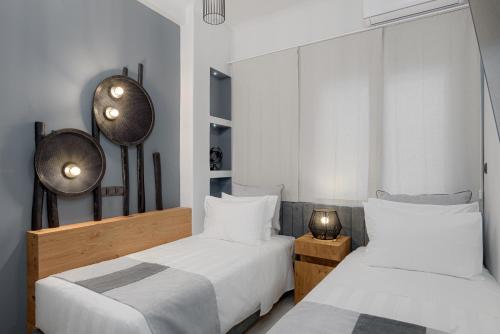 2 camas en una habitación con paredes blancas en Acropolis Deluxe Apartment, en Atenas