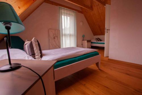 ein Schlafzimmer mit einem Bett und einem Schreibtisch mit einer Lampe in der Unterkunft Ferienhaus Leonrod in Dietenhofen