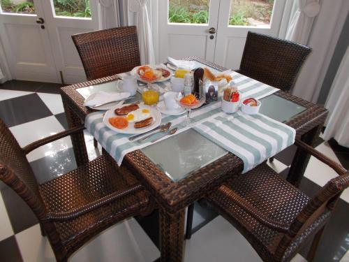 een tafel met een ontbijt van eieren en pannenkoeken bij Coral Tree Colony Bed & Breakfast in Southbroom