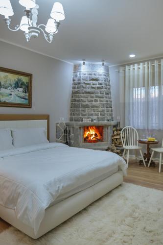 a bedroom with a bed and a fireplace at Vila 1 in Korçë