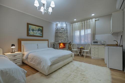 a bedroom with a large bed and a fireplace at Vila 1 in Korçë