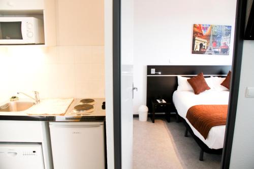 a small room with a bed and a sink at Park Wilson Airport in Colomiers