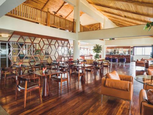 a restaurant with wooden floors and tables and chairs at Mövenpick Hotel & Residences Nairobi in Nairobi