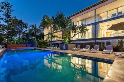 a swimming pool in front of a building at The Rise Noosa in Noosa Heads