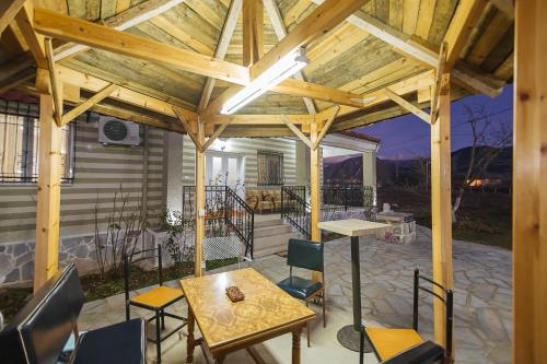 a wooden pergola with a table and chairs on a patio at Vila 1 in Korçë