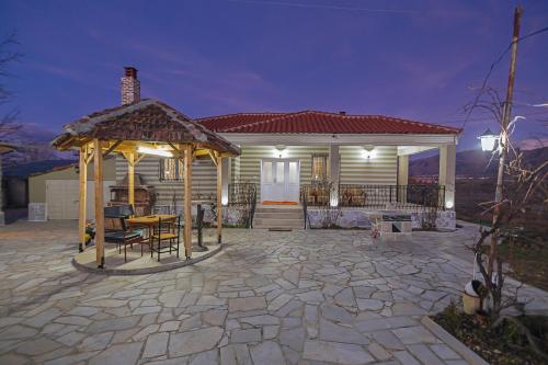 een huis met een prieel op een stenen patio bij Vila 1 in Korçë
