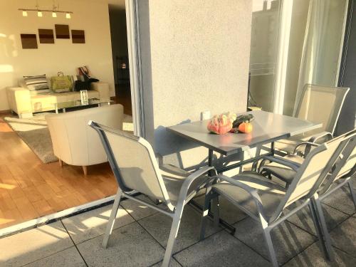 uma mesa e cadeiras numa sala de estar em Close To Unil EPFL, Spacious and Modern ! em Lausanne