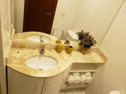 a bathroom with a sink and a mirror at Apartamento Knorrville 306 in Gramado
