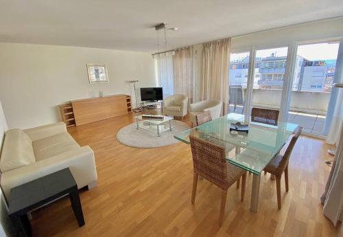 - un salon avec un canapé et une table en verre dans l'établissement Modern, bright and spacious 3 bedrooms 2 bathrooms, à Lausanne