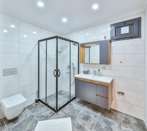 uma casa de banho com um chuveiro, um WC e um lavatório. em Villa Dundar - Kas Apartments em Kas