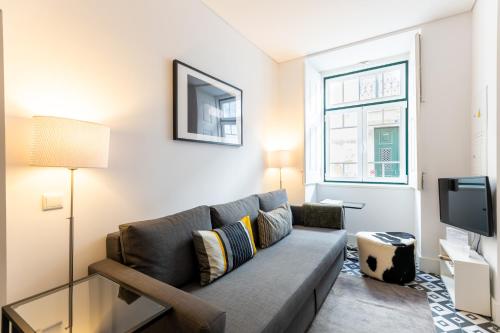 a living room with a couch and a tv at Villa Graça -Hostels and Apartments in Santarém