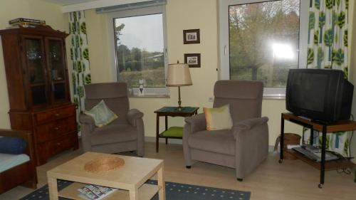 a living room with two chairs and a tv at Ferienwohnung Oppermann in Arholzen