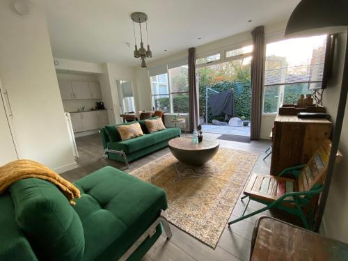 a living room with a green couch and a table at Hotel Oranjestaete in Nijmegen