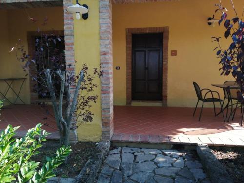 a front door of a house with a table and chairs at Relais Poggio al Vento in Pomarance