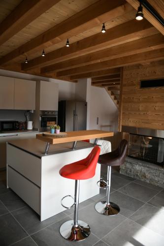 une cuisine avec un comptoir et deux tabourets dans l'établissement Le Mazot d'la Marmotte T3, à Passy