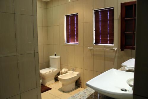 a bathroom with a toilet and a sink at Prinshof Manor Guesthouse in Pretoria
