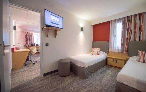 a room with two beds and a tv on the wall at Promotel in Carros