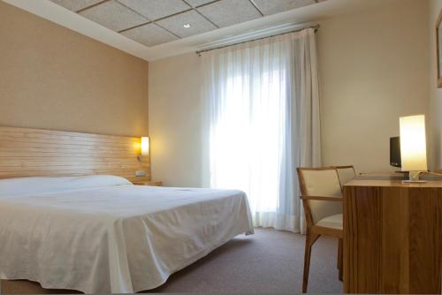 Habitación de hotel con cama y ventana en Hotel Bulevard, en Benicàssim