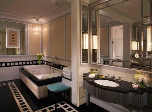 a bathroom with a tub and a large mirror at InterContinental Singapore by IHG in Singapore