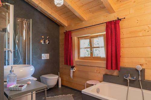 a wooden bathroom with a tub and a toilet at Alchemilla in Bad Feilnbach