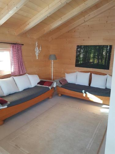a room with two beds in a log cabin at Alchemilla in Bad Feilnbach