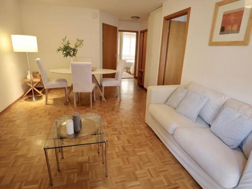 a living room with a white couch and a table at Comfortable, very well located between train station and lake! in Lausanne