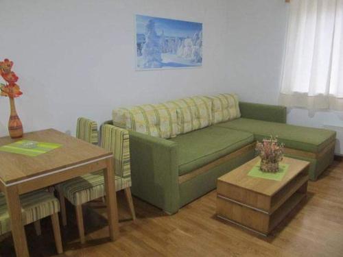 a living room with a green couch and a table at Vila Bjanka in Zlatibor