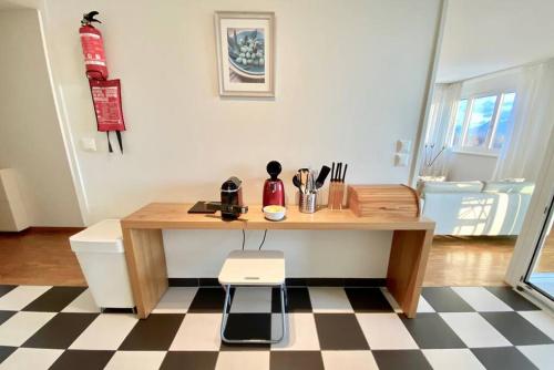 cocina con mesa de madera y suelo a cuadros en Your bright and spacious apartment by the lake en Lausana