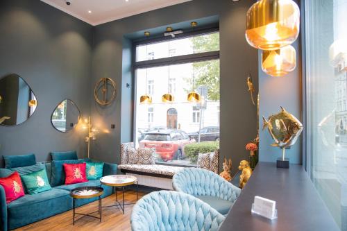 a living room with a blue couch and chairs at Munich Rooms Hotel in Munich