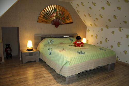 um urso de peluche sentado numa cama num quarto em Breizh A-Gevret em Lannion