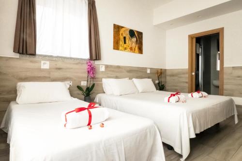 two beds in a hotel room with red bows on them at Eurohotel in Milan