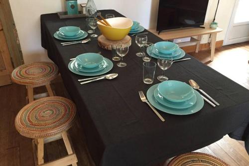 une table avec un chiffon de table noir, avec des assiettes et de l'argenterie dans l'établissement Charme assuré pour ce logement idéalement situé, à Arcachon