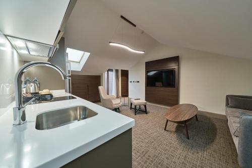 a kitchen with a sink and a living room at Selini Hotel İstanbul Airport in Istanbul