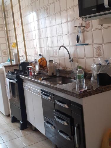 a kitchen counter with a sink and a stove at ALVORADA PLACE in Santo André