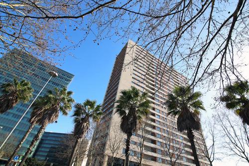 a tall building with palm trees in front of it at Panoramic in Travel, Parque das Nações in Lisbon