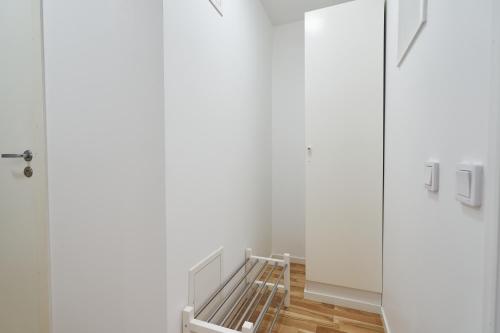 a hallway with white walls and a glass door at Bålsta Apartment Hotel in Bålsta
