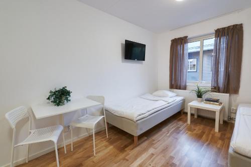 a white room with a bed and a table and chairs at Bålsta Apartment Hotel in Bålsta