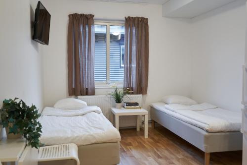 a bedroom with two beds and a window at Bålsta Apartment Hotel in Bålsta