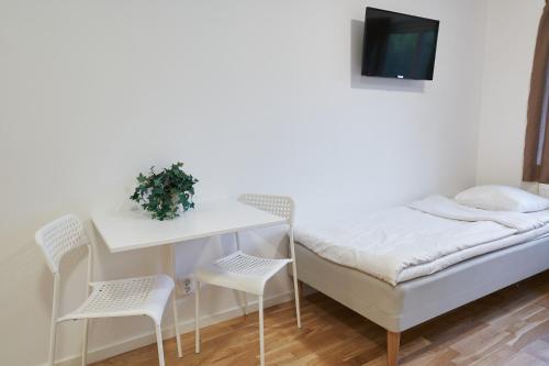 a room with a bed and a desk and chairs at Bålsta Apartment Hotel in Bålsta