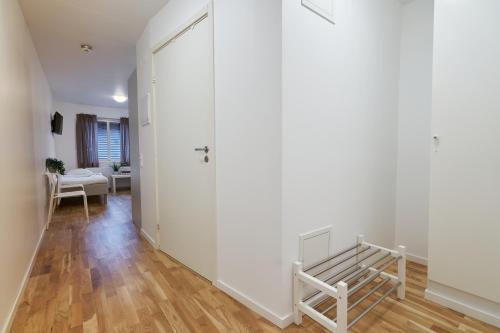a hallway with white walls and a wooden floor at Bålsta Apartment Hotel in Bålsta