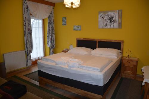 a bedroom with a bed in a room with yellow walls at Hotel Rosenberg in Jennersdorf