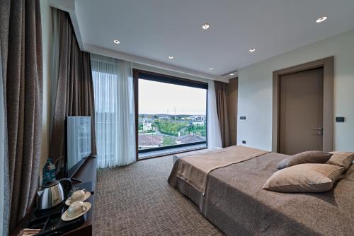 a bedroom with a bed and a large window at Selini Hotel İstanbul Airport in Istanbul